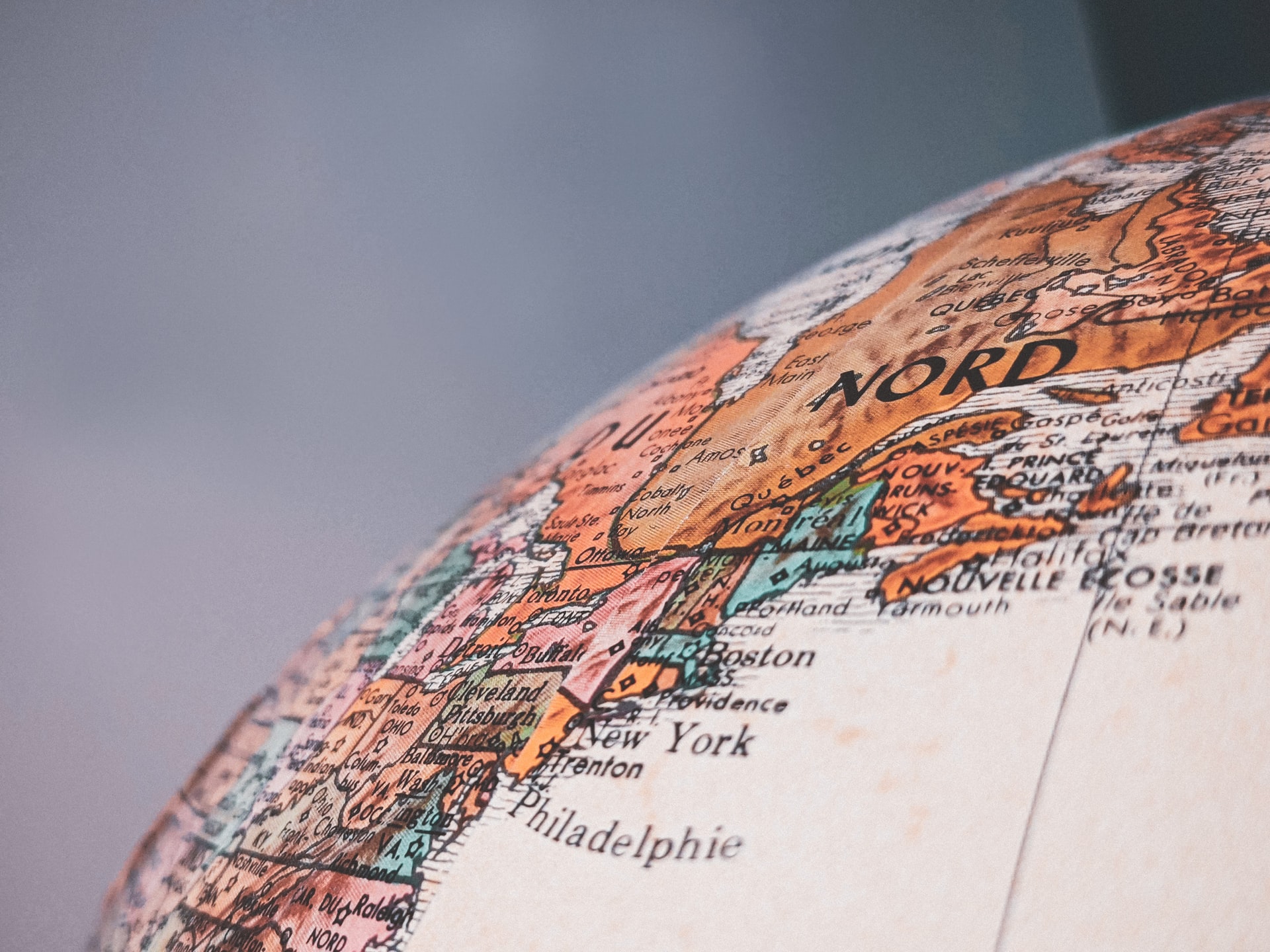 Globe, showing North America. Marked cities include New York, Boston, and Philadelphia. Orange and blue hues.